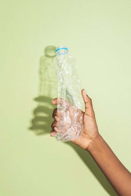 Hand met een verpletterde plastic fles