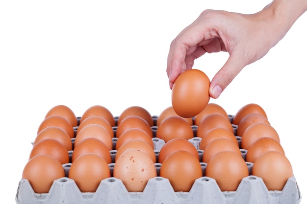 Hand met ei op een witte achtergrond.