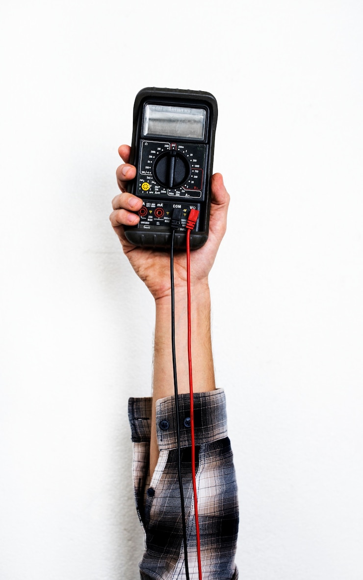 Foto hand met elektriciteit meten multimeter geïsoleerd op wit