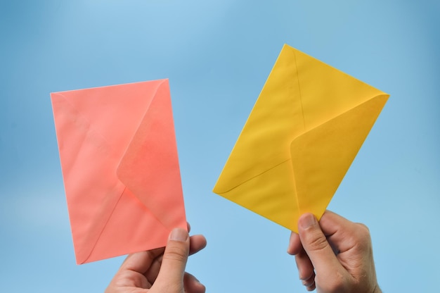 Hand met enveloppen geïsoleerd op een blauwe achtergrond