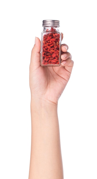 hand met fles Goji Wolfberries geïsoleerd op een witte achtergrond