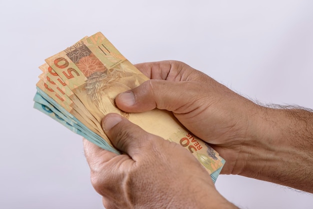 Hand met geld zeshonderd reais Braziliaanse valuta op witte achtergrond