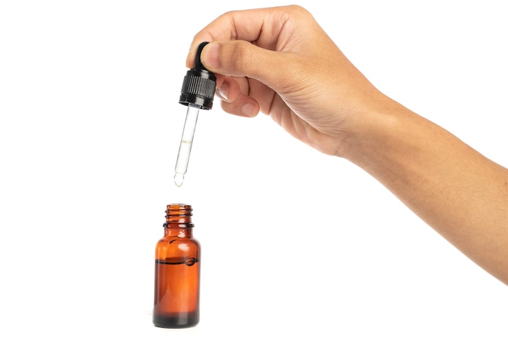 Foto hand met glazen pipet etherische oliën fles geïsoleerd op een witte achtergrond