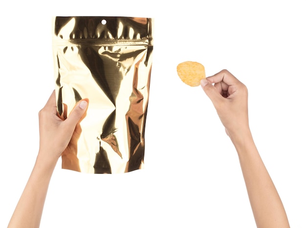 Hand met gouden lege plastic aardappel snack zak verpakking met zip-lock geïsoleerd op een witte achtergrond.