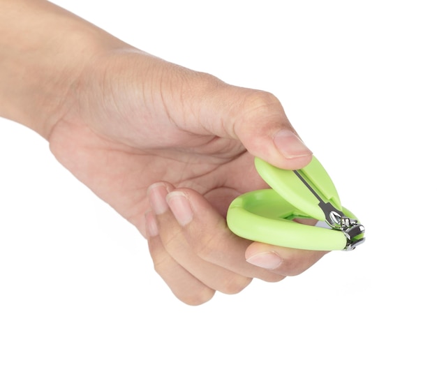 Hand met groene nagelknipper voor baby's geïsoleerd op een witte achtergrond.