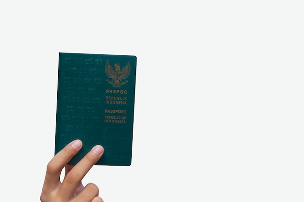 Hand met groene paspoort republiek Indonesië geïsoleerd op een witte achtergrond