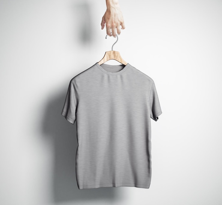 Foto hand met hanger met lege grijze t-shirt op betonnen muur achtergrond ontwerp en winkelconcept mock up 3d rendering