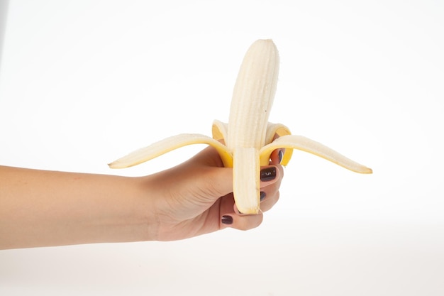 Hand met hele banaan geïsoleerd op een witte achtergrond