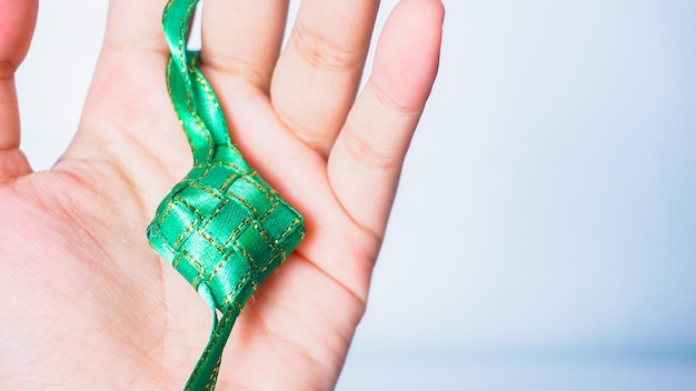 Hand met ketupat een van de traditionele gerechten uit Indonesië Selectieve focus Ramadan concept