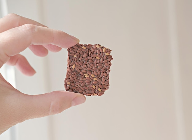 Foto hand met knapperige meergranengranen lijnzaad knäckebröd repen voor gezonde snacks energierepen zonder toegevoegde suikers