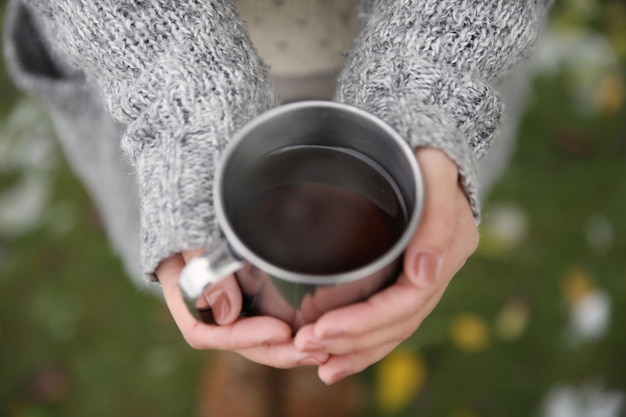 Hand met koffiekopje buitenshuis