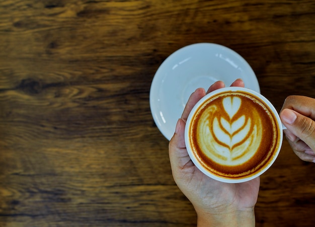 Hand met koffiekopje op tafel