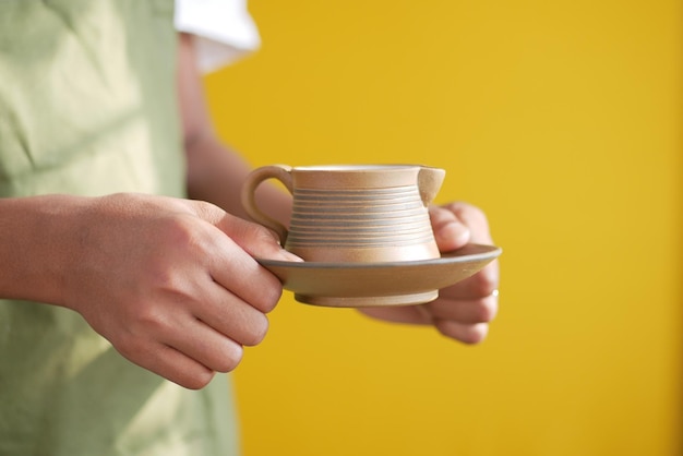 Hand met kopje groene thee met kopie ruimte