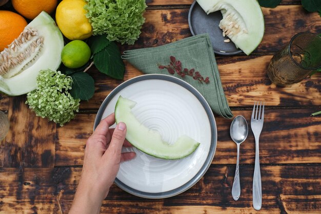 Hand met meloenplak die gezond zomerfruit eet Buiten dineren