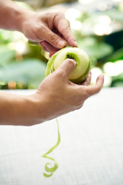 Hand met mes peeling appelhuid