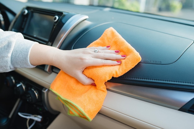 Hand met microvezeldoekreinigingsstoel, auto-detaillering en parkeerconcept, auto-interieur wassen, selectieve focus