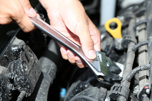 Hand met moersleutel Automonteur in autoreparatie