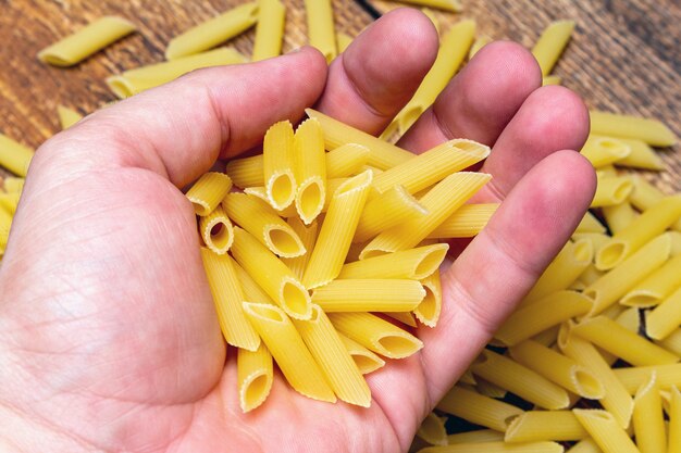 Hand met penne pasta