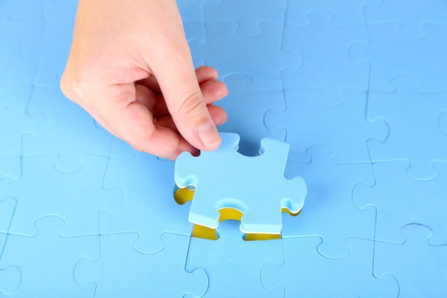 Hand met puzzelstukje close-up