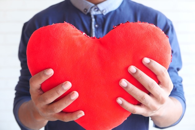 hand met rood hartsymbool op witte achtergrond