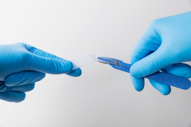 Foto hand met rubberen handschoen met medische scalpel