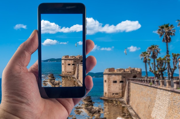 Hand met smartphone die foto's maakt op een zonnige dag