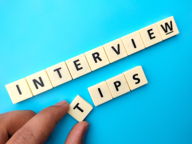 Foto hand met speelgoed woord met tekst interview tips op blauwe achtergrond