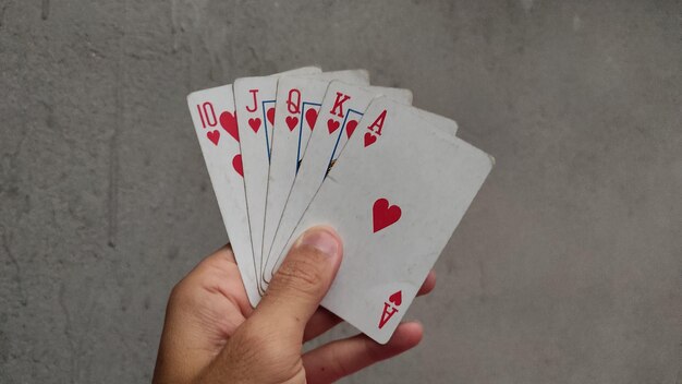 Hand met speelkaarten harten voor het gokken poker spel
