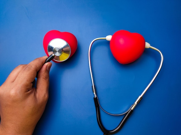 Hand met statehoscope die rood hart controleert Gezondheidszorg en medisch concept