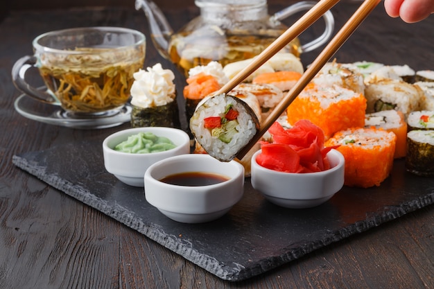 Hand met sushi zalm roll in stokjes met kopie ruimte voor ontwerpwerk