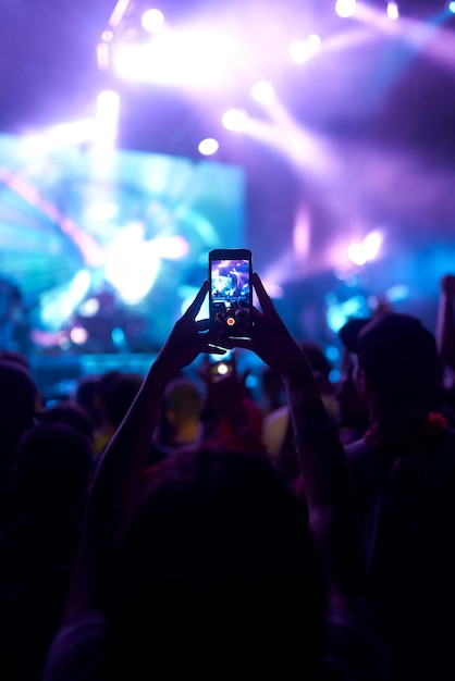 Hand met telefoon opnemen live muziekfestival Mensen die foto's maken met smartphone tijdens concert