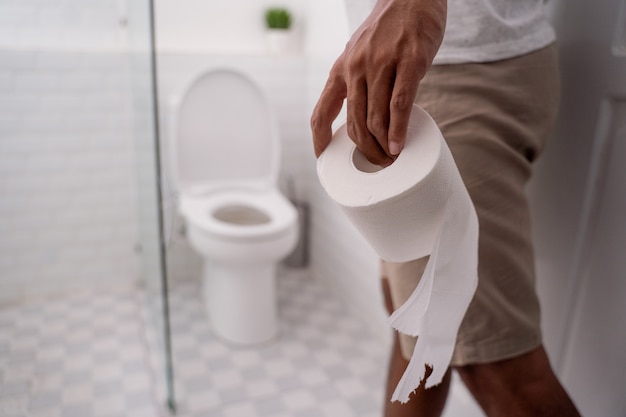 Hand met toiletpapier voordat u het gebruikt