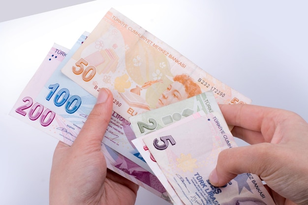 Hand met Turkse Lira bankbiljetten in de hand