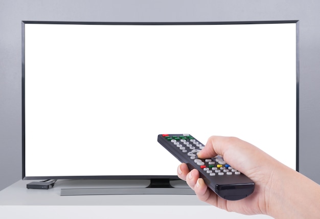 Hand met tv-afstandsbediening met led-tv en wit scherm
