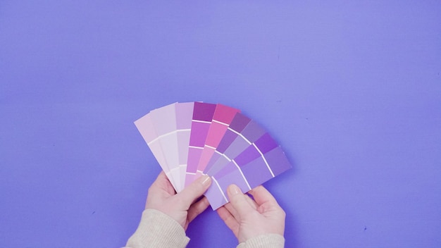 Foto hand met verfstalen met tinten violette kleuren.
