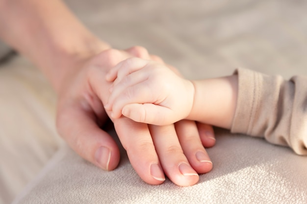 Hand met vingers van een pasgeboren baby en mama's hand.