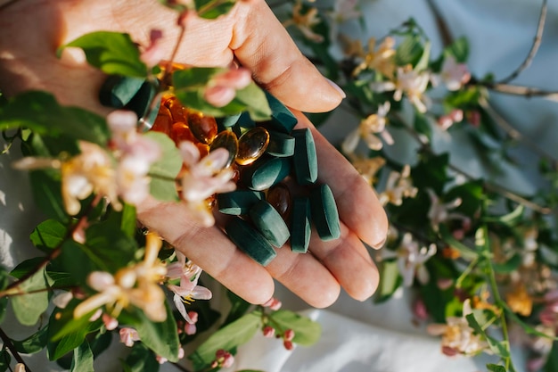 Foto hand met vitamines en mineralen in bloemen