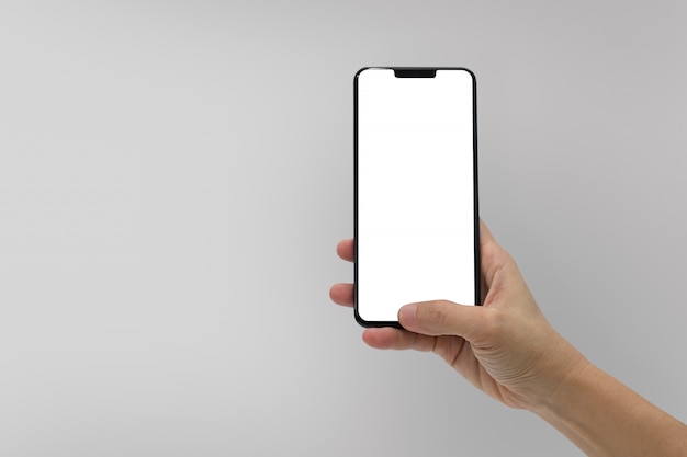 Hand met zwarte mobiele telefoon met leeg scherm geïsoleerd op grijs