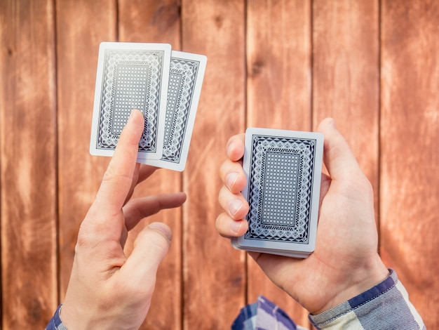 Hand mixing playing cards over the wooden surface