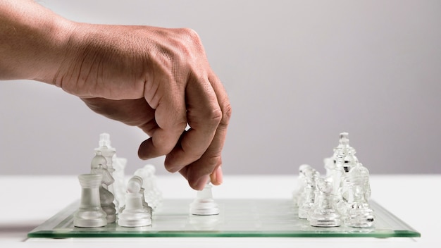 Photo hand moving transparent chess pieces