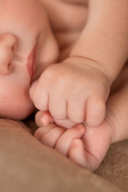 The hand of a newborn clenched into a fist Health care pediatrics Motherhood Newborn and parent Baby