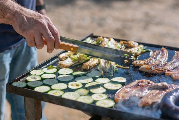 写真 バーベキューで料理をする人の手