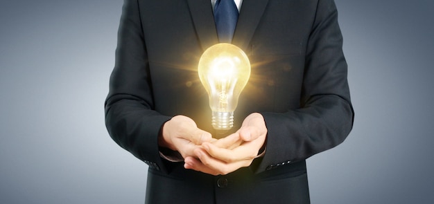 照らされた電球、アイデアイノベーションインスピレーションコンセプトを保持の手