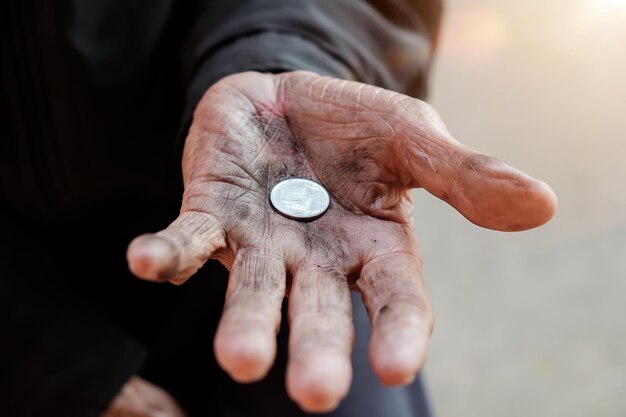 hand old man begging for money because of the hunger on the wood table vintage tone