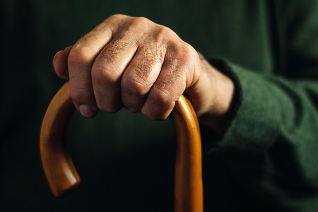 Hand of an old man holding a walking stick