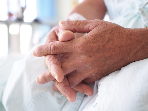 The hand of the old man sitting alone in hospital