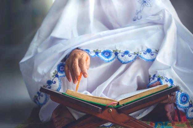 Hand of old muslim woman recites quran