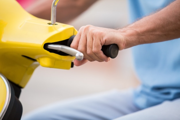 Hand op het stuur van de scooter.