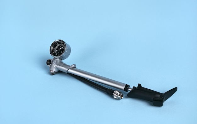 Hand operated high pressure air pump for air shocks and forks with manometer isolated on blue background