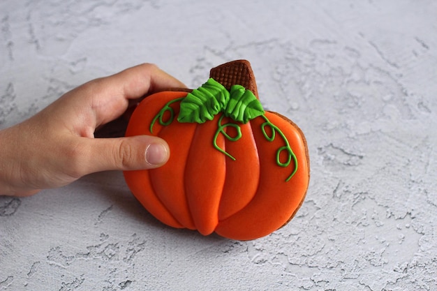 Hand-painted gingerbread in the form of pumpkins on a light background in the hand. High quality photo